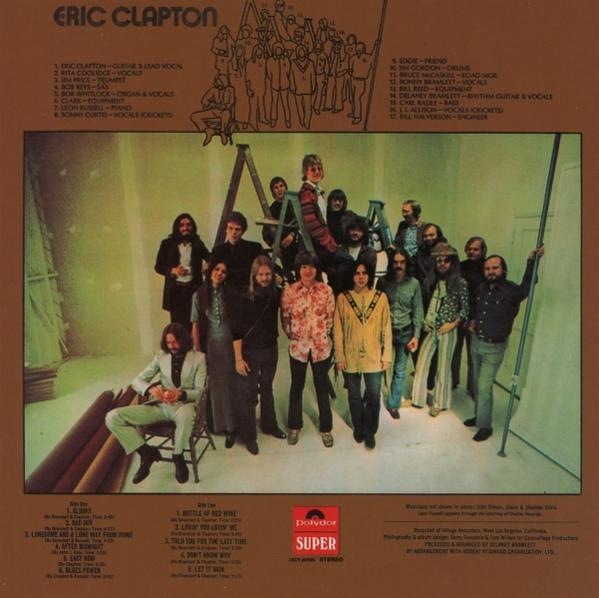 Gruppe posiert für ein Foto. Eric Clapton Albumcover mit Text und braunem Hintergrund.
