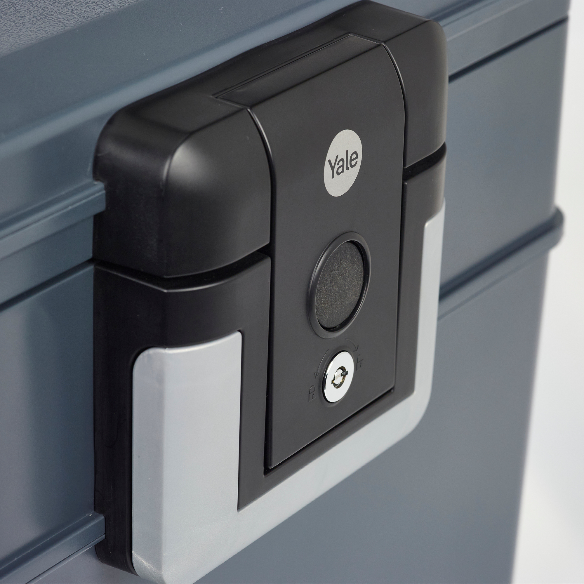 Nahaufnahme eines grau-schwarzen Yale-Safes. Er hat ein Schlüsselloch, ein kreisförmiges Schloss und ein Yale-Logo.
