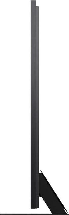 Un téléviseur noir et fin vu de côté. Il est posé sur un support noir. Fond blanc.