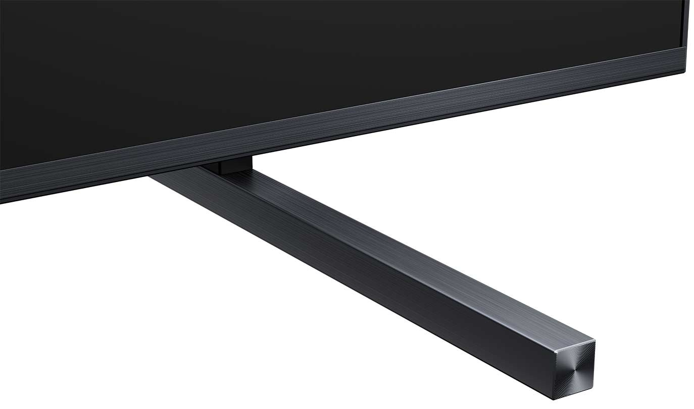 Zbliżenie ekranu telewizora i jego podstawy. Ekran jest czarny, a podstawa ma prostokątny kształt w ciemnoszarym kolorze.