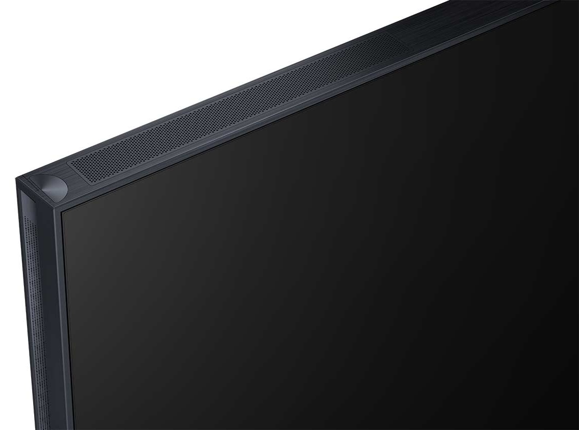 Zbliżenie czarnego ekranu telewizora. Górna krawędź pokazuje kratki głośników i róg z okrągłym wzorem.