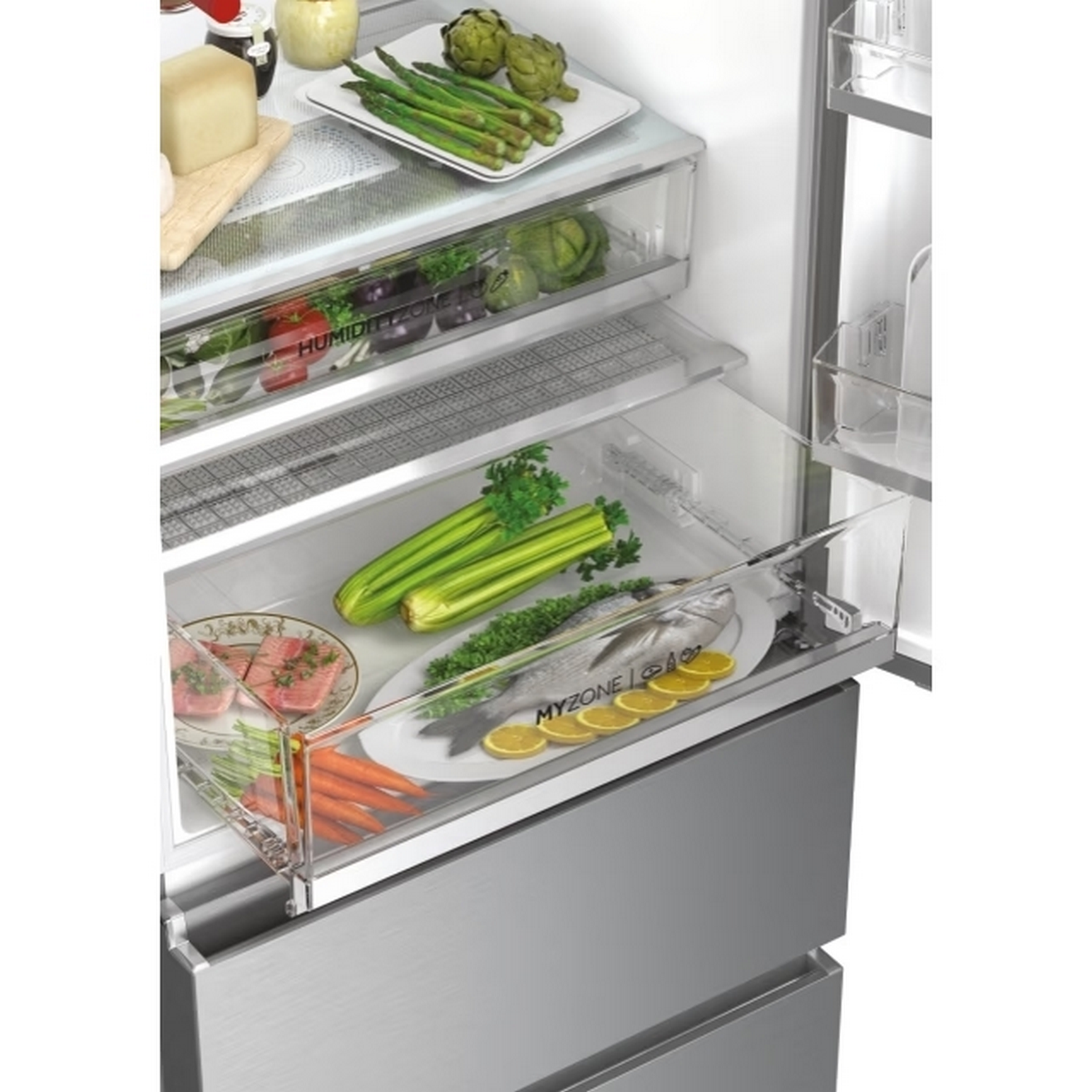 Dentro de un refrigerador: espárragos, alcachofas, verduras, pescado, zanahorias y limones. Algunos alimentos están en platos y el refrigerador está abierto.
