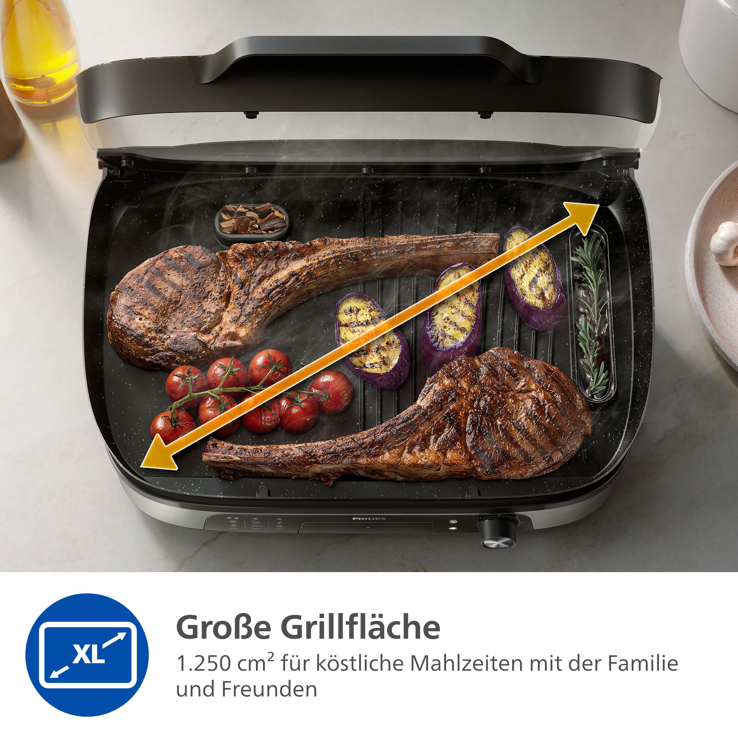 Gegrilltes Steak, Tomaten und Aubergine auf einem Elektrogrill. Der Grill hat eine große Fläche mit einem XL-Symbol.