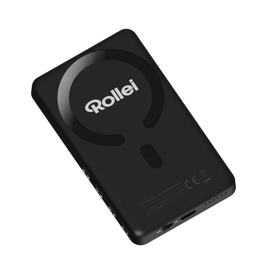 Ein schwarzer Rollei Easy Creator Selfie Monitor. Es hat ein kreisförmiges Design auf der Rückseite. Der Markenname Rollei ist weiß.