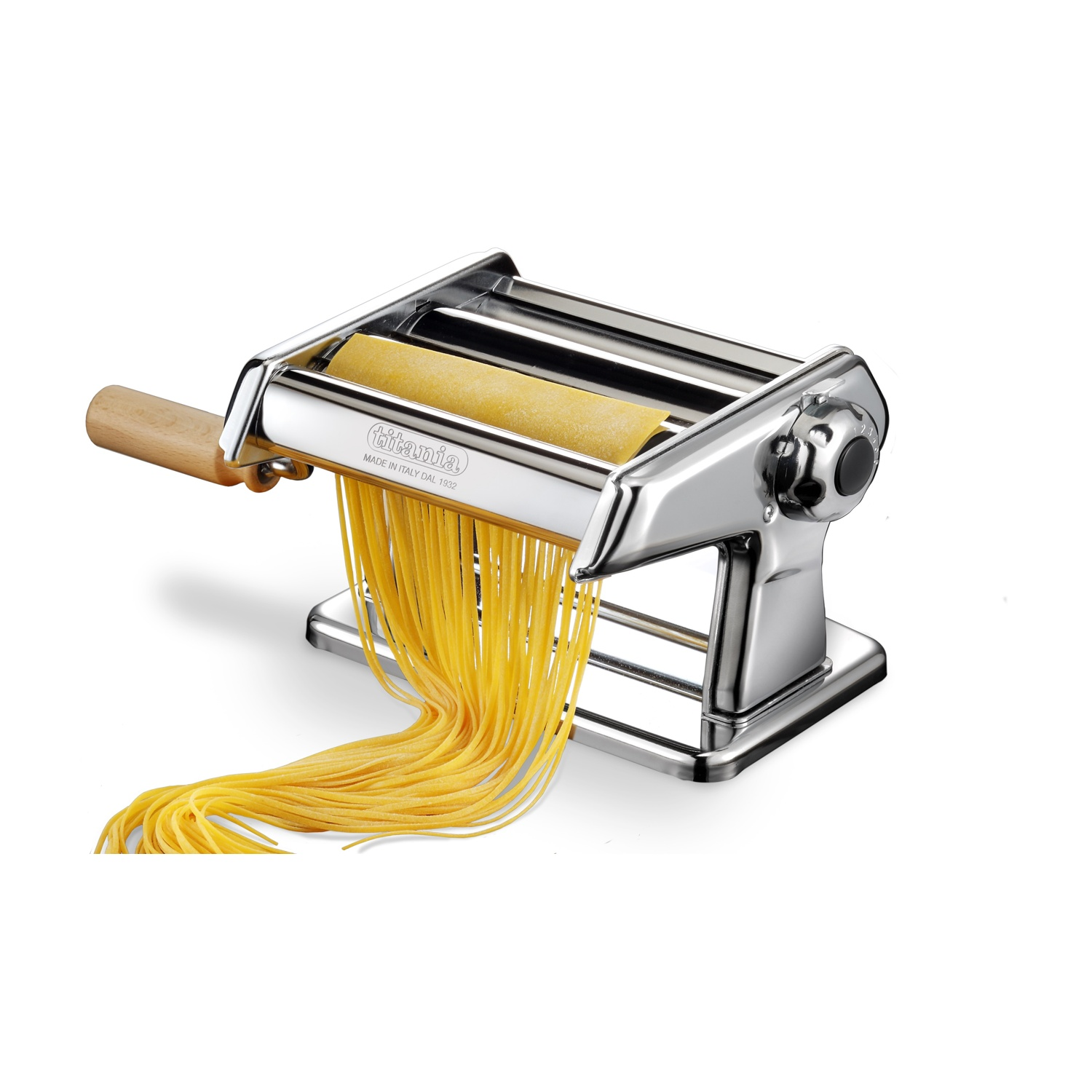 Una macchina per la pasta con manico in legno sta facendo spaghetti. Un foglio di pasta viene arrotolato e tagliato. La macchina è argentata.