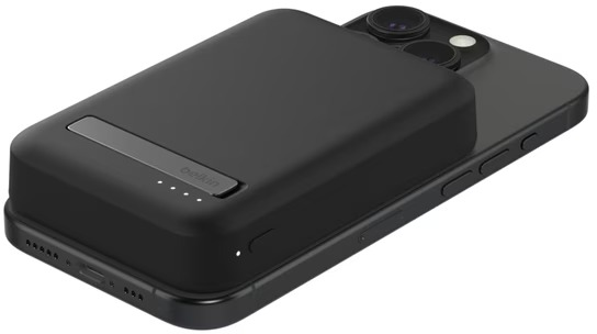Téléphone noir avec un chargeur Belkin noir dessus. Le chargeur a une bande argentée et des voyants de charge blancs.