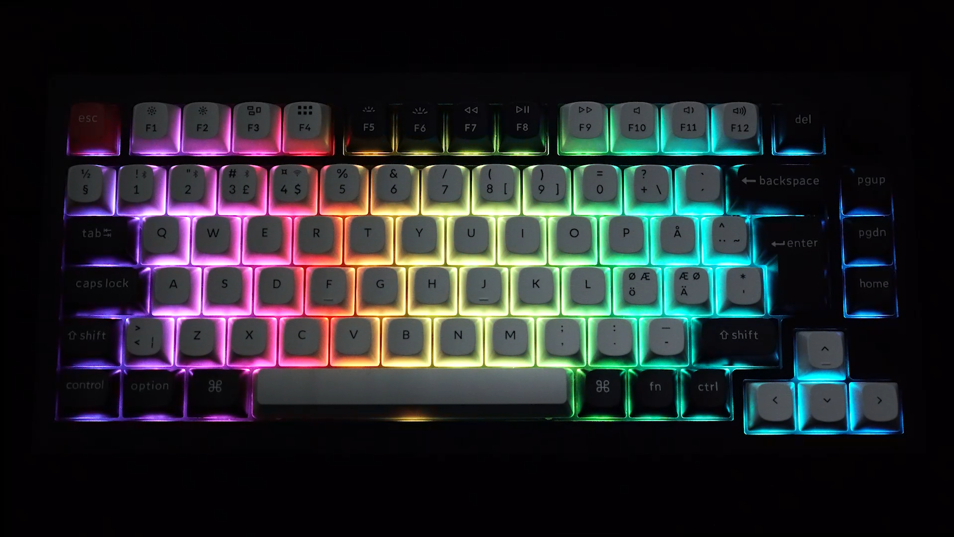 Eine mechanische Tastatur mit Hintergrundbeleuchtung in Regenbogenfarben. Tasten sind weiß mit schwarzen Buchstaben.