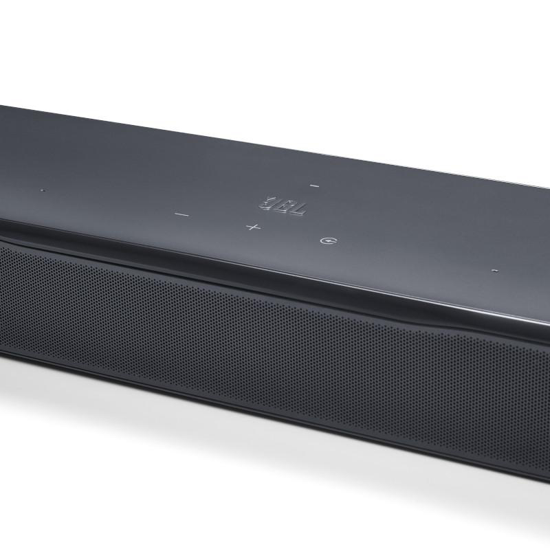 Eine schwarze JBL-Soundbar. Sie hat eine Mesh-Front, Bedienelemente oben und das JBL-Logo. Der Hintergrund ist weiß.