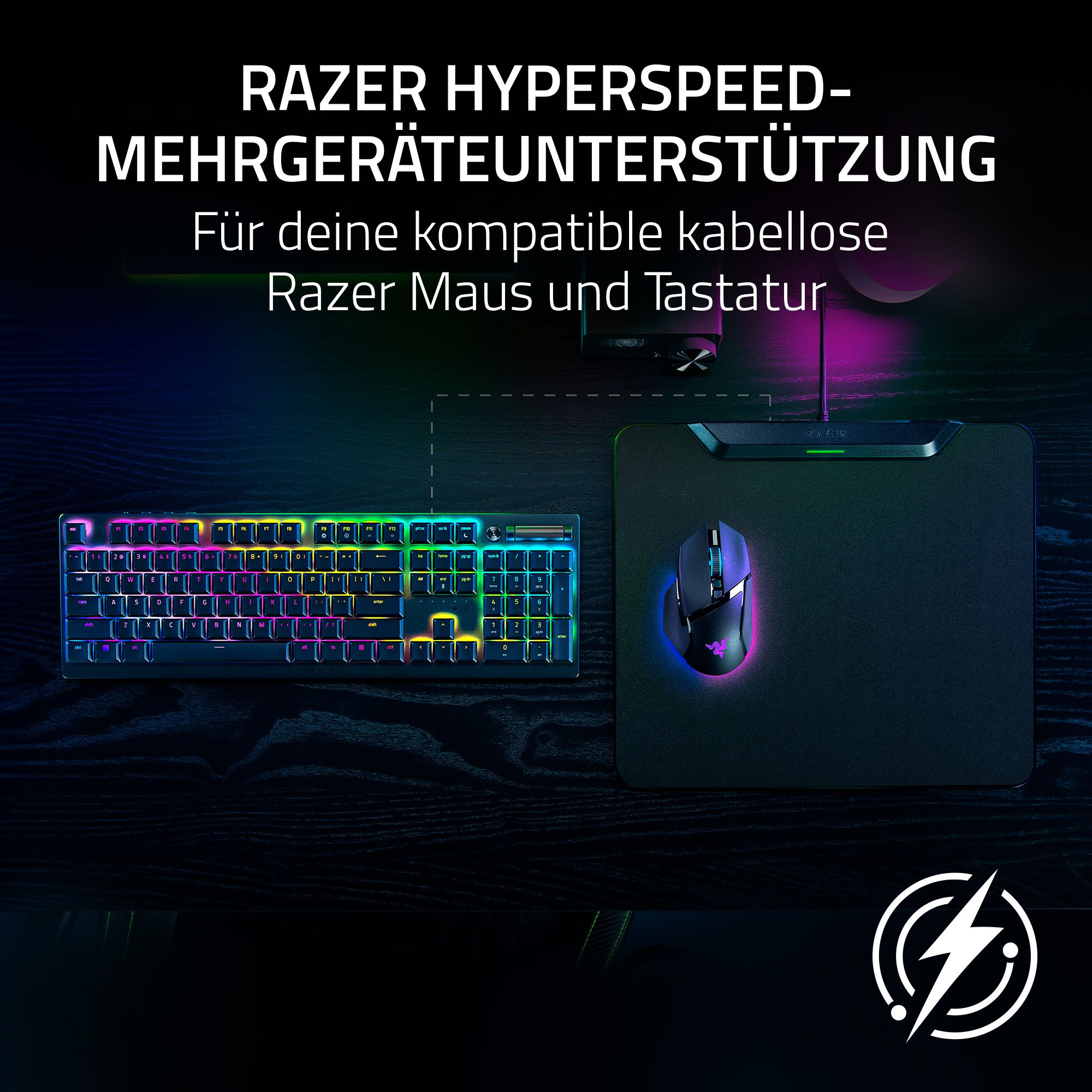 Razer-Tastatur, Maus und Mauspad auf dunkler Oberfläche. Die Tastaturtasten leuchten. Razer-Logo sichtbar.