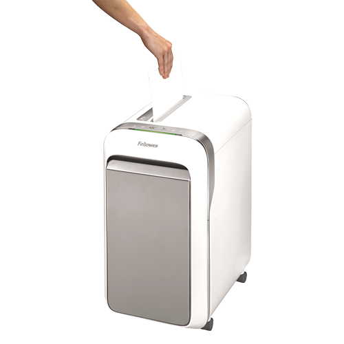 Una mano inserta un papel blanco en una destructora de papel Fellowes blanca y gris sobre un fondo blanco.
