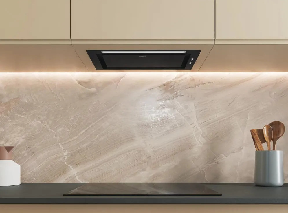 Scena kuchenna z czarnym okapem, marmurowym blatem i drewnianymi przyborami kuchennymi. Widoczna jest również kuchenka i szafki.