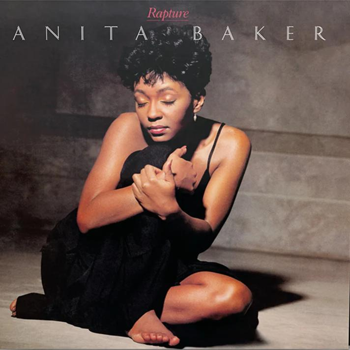 Anita Baker album borítója. Fekete ruhát visel, átöleli magát. A neve felett a "Rapture" szó látható.