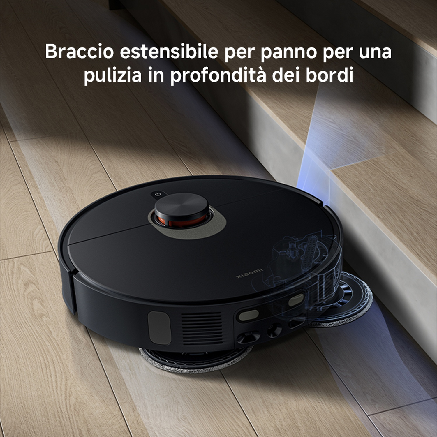 Un aspirapolvere robotico nero su un pavimento in legno. Ha un corpo rotondo e un tampone per la pulizia. Il testo dice che pulisce i bordi.