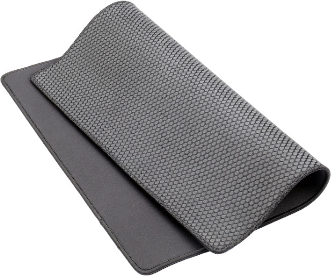 Dwie szare podkładki pod mysz są nałożone na siebie. Górna ma wzór plastra miodu. Dolna jest gładka. Obie mają ciemne krawędzie.