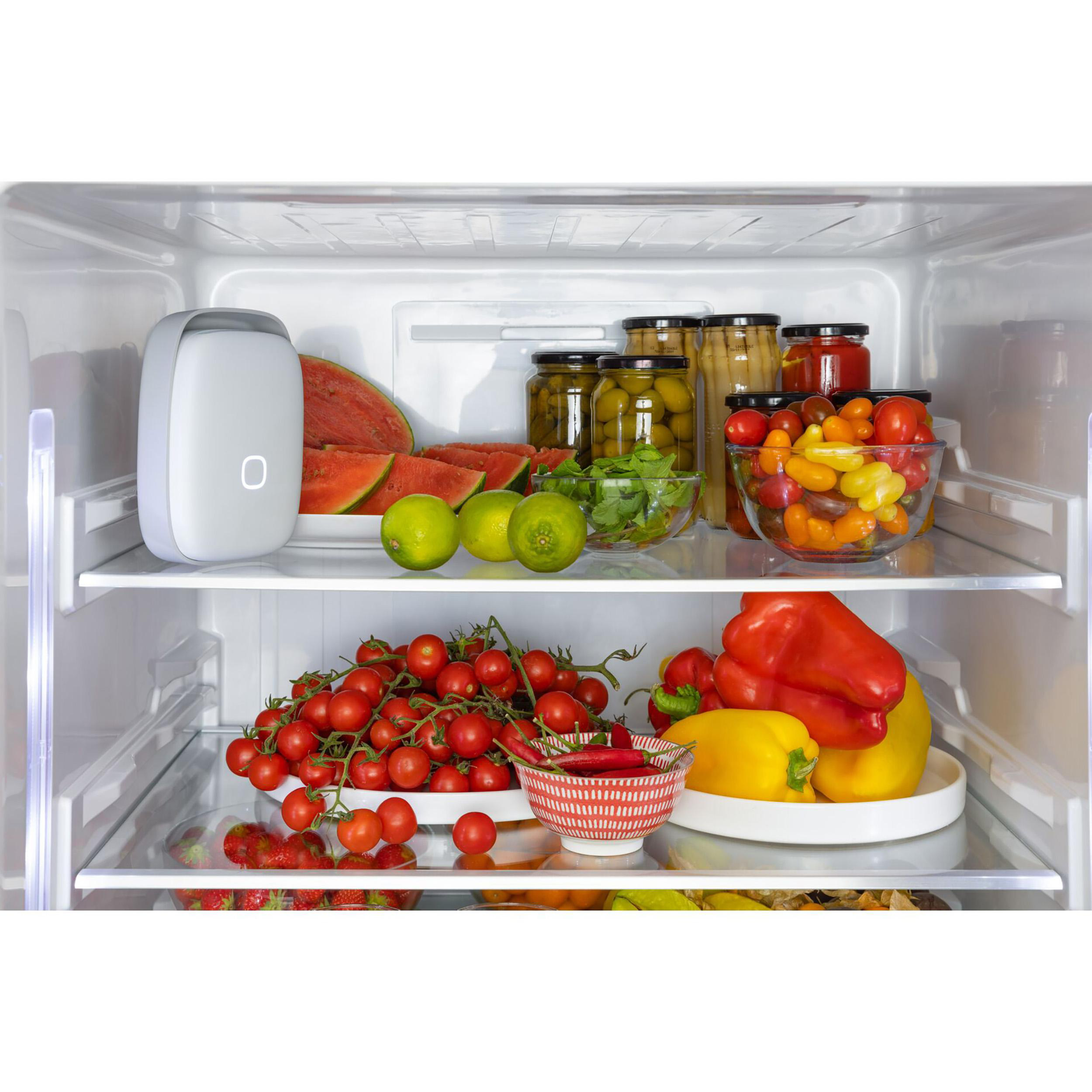 In einem Kühlschrank: Wassermelone, Limetten, Tomaten, Paprika und Gläser mit Lebensmitteln.