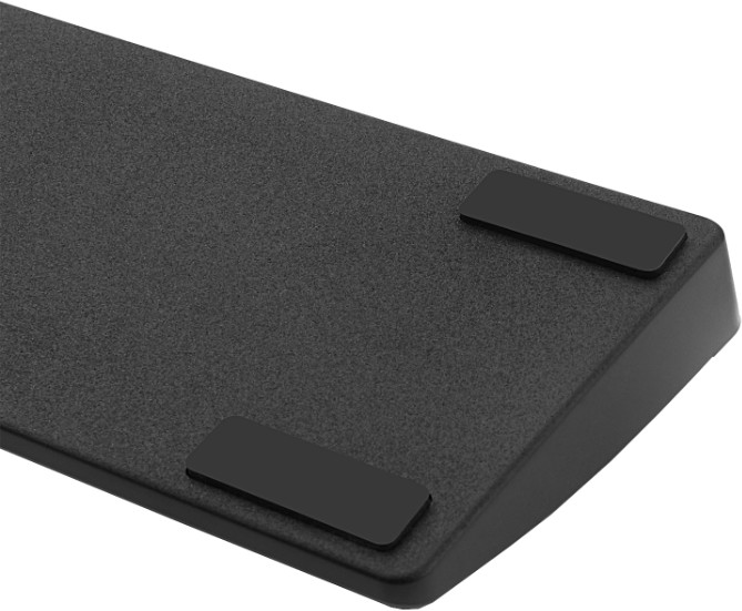 Czarna, teksturowana powierzchnia z dwiema czarnymi prostokątnymi podkładkami. Powierzchnia lekko wznosi się ku górze, z dwoma kolejnymi podkładkami.