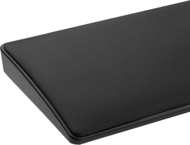 Zbliżenie czarnego, prostokątnego przedmiotu z zaokrąglonymi rogami i teksturowaną powierzchnią, prawdopodobnie akcesorium biurowe.