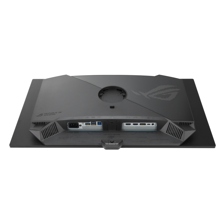 Vista trasera de un monitor de ordenador gris oscuro. Cuenta con puertos, ventilaciones y el logotipo ROG. El monitor está sobre un fondo negro.