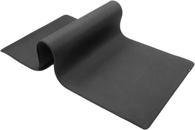 Ciemnoszara, zwinięta, prostokątna podkładka pod mysz. Górna warstwa jest gładka, zwinięta część odsłania teksturowany spód.