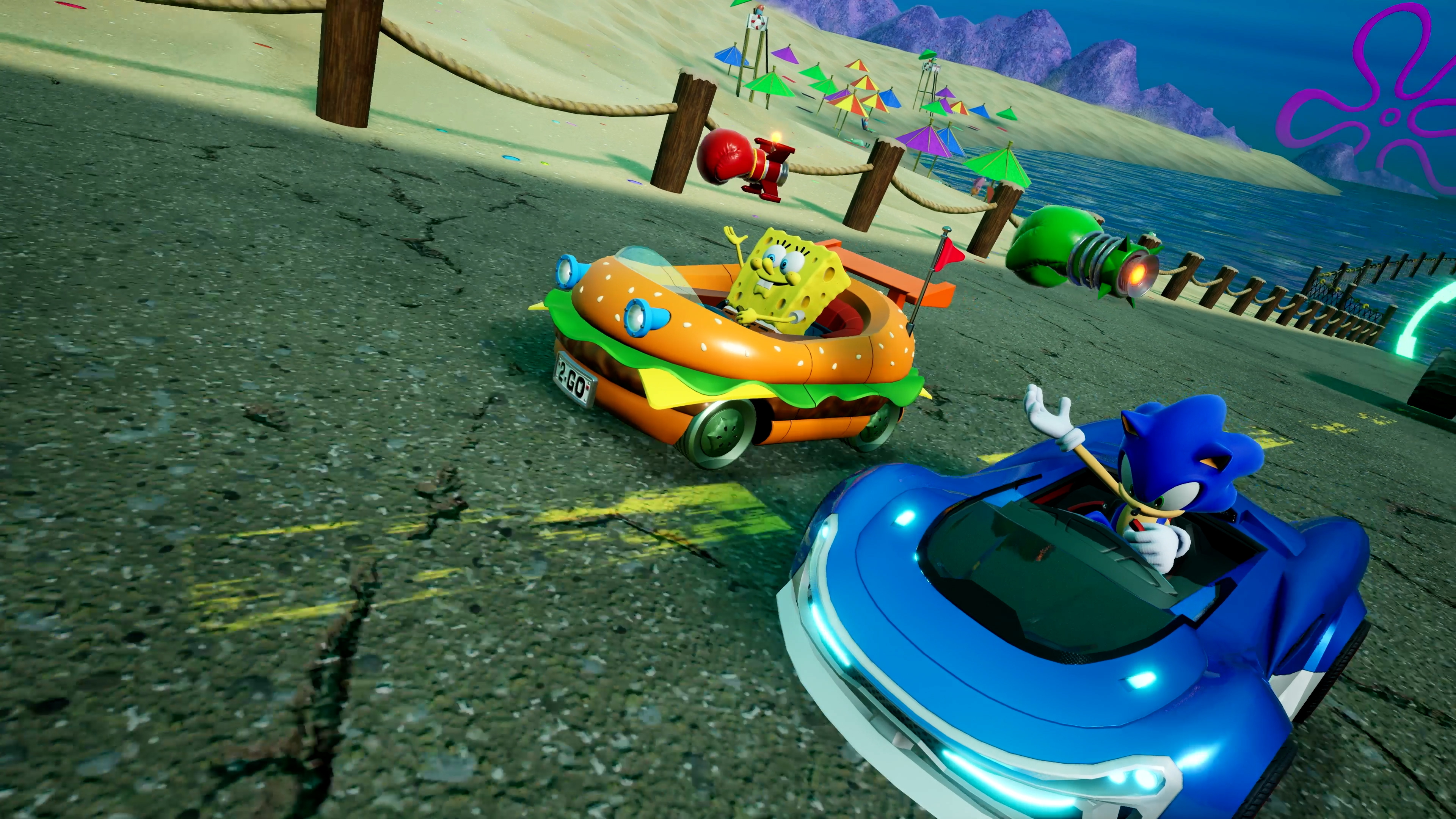Bob l'éponge dans une voiture burger affronte Sonic dans une voiture bleue sur une piste sur le thème de la plage. Le fond comprend des détails de plage et de mer.