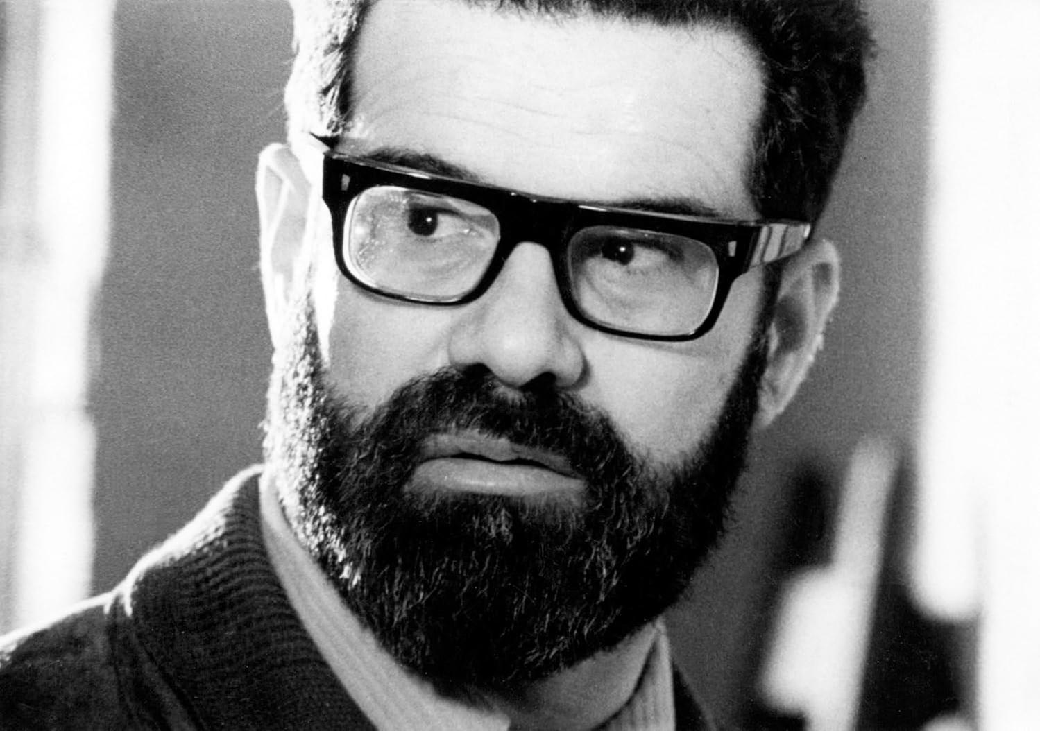 Ein Mann mit Brille und Bart schaut zur Seite. Das Foto ist in Schwarzweiß.
