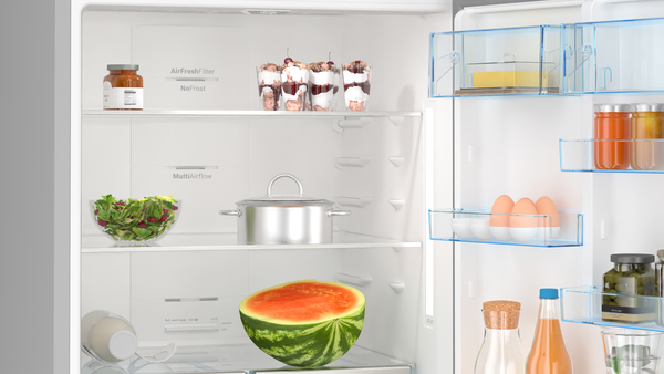 Yiyecek dolu bir buzdolabı. Karpuz, salata, kavanoz, yumurta ve tatlılar görünür. Raflar iyi düzenlenmiş.