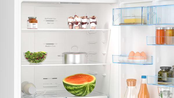 Yiyecek dolu bir buzdolabı içi: salata, kavanoz, tatlılar, karpuz, yumurta, tereyağı ve çeşitli şişeler ve kavanozlar.