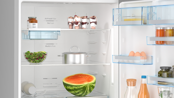 İçinde yiyecek olan açık buzdolabı: karpuz, salata, tencereler, kavanozlar, yumurtalar ve tatlılar.