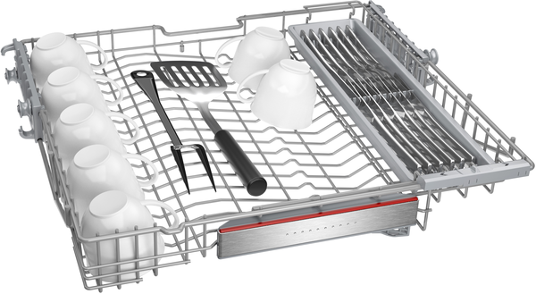 Bulaşık makinesi rafı beyaz kupalar, bir spatula, bir çatal ve bir mutfak eşyası rafı ile. Raf metaldir.
