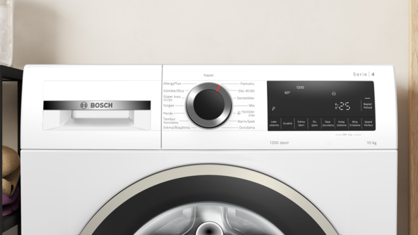 Siyah kontrol panelli beyaz bir Bosch çamaşır makinesi. Bir kadranı ve zamanı ve ayarları gösteren dijital bir ekranı vardır.