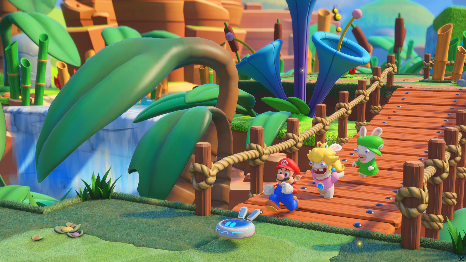 Mario- und Rabbids-Charaktere auf einer Holzbrücke. Grüner Rabbid, Peach und Mario rennen. Große Blätter und blaue blütenartige Strukturen im Hintergrund.