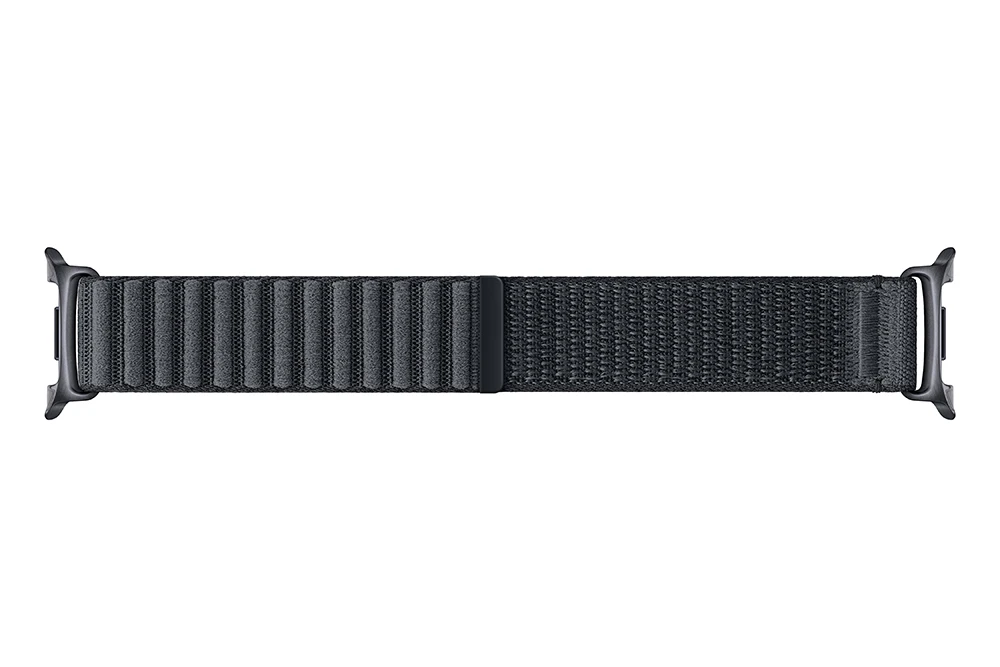 Egy sötétszürke Apple Watch szíj fehér háttéren. A szíj texturált anyagból készült, mágneses záródással.