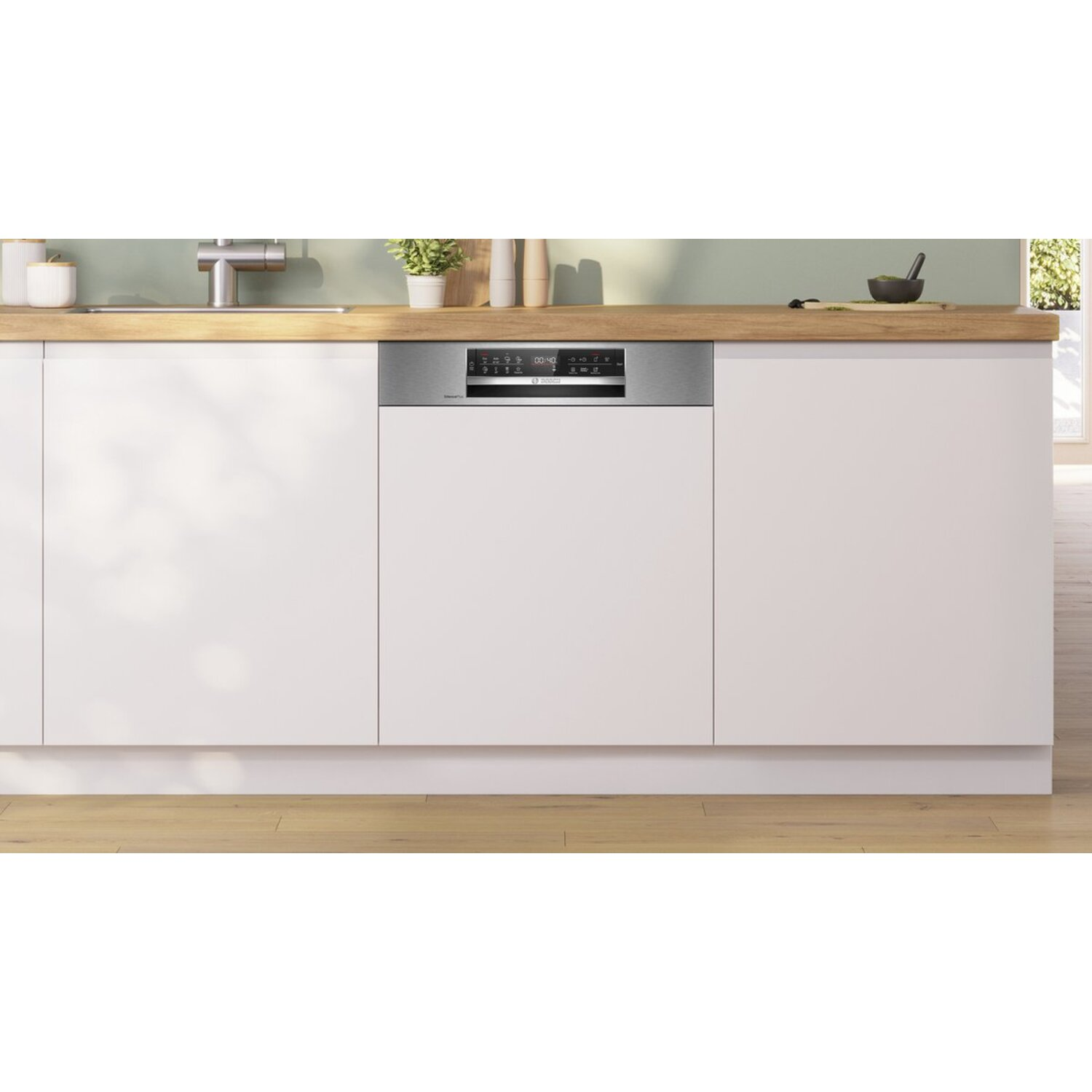 Een moderne keuken met een vaatwasser ingebouwd in witte kasten. Een houten aanrecht heeft een gootsteen en kleine planten.