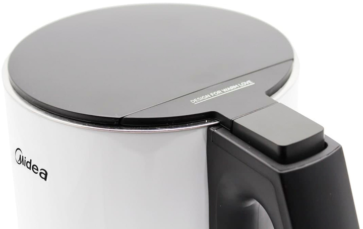 Zbliżenie białego i czarnego czajnika elektrycznego. Pokrywka jest czarna z napisem 'DESIGN FOR WARM LOVE'. Uchwyt jest czarny.