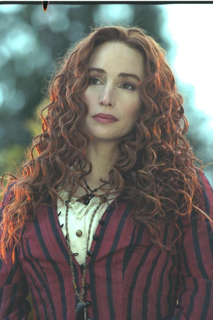 Eine Frau mit roten Locken trägt eine rot gestreifte Jacke. Sie hat helle Haut und schaut leicht nach links.