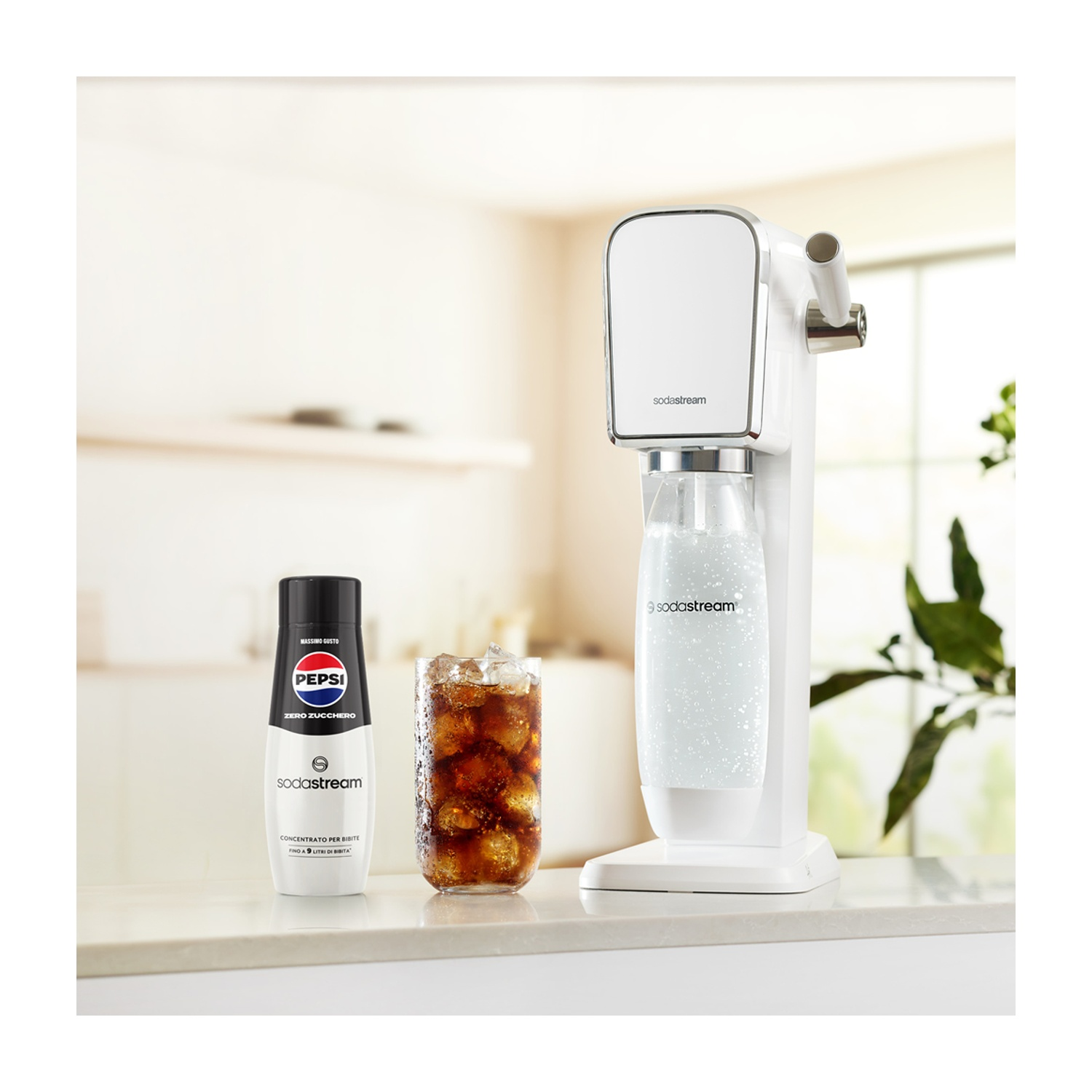 Una macchina SodaStream bianca, una bottiglia di Pepsi e un bicchiere di cola su un bancone. Lo sfondo mostra una cucina.