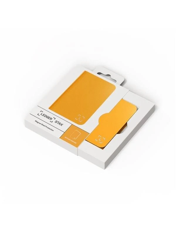 Una caja blanca contiene una tarjeta Ledger Stax naranja y un tarjetero. La caja está sobre una superficie blanca.