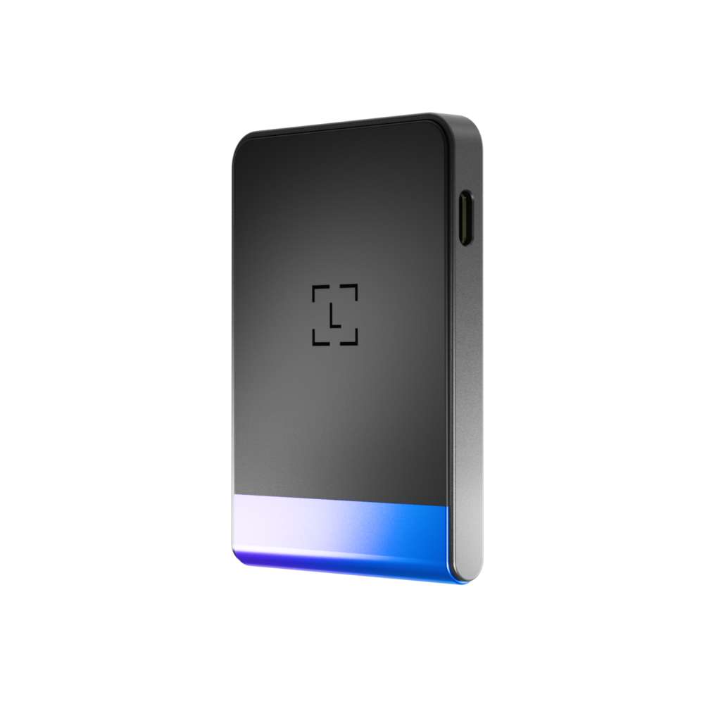 Un dispositivo rectangular con marco metálico. Tiene cuerpo negro, base azul claro y morado, e icono cuadrado en el centro.