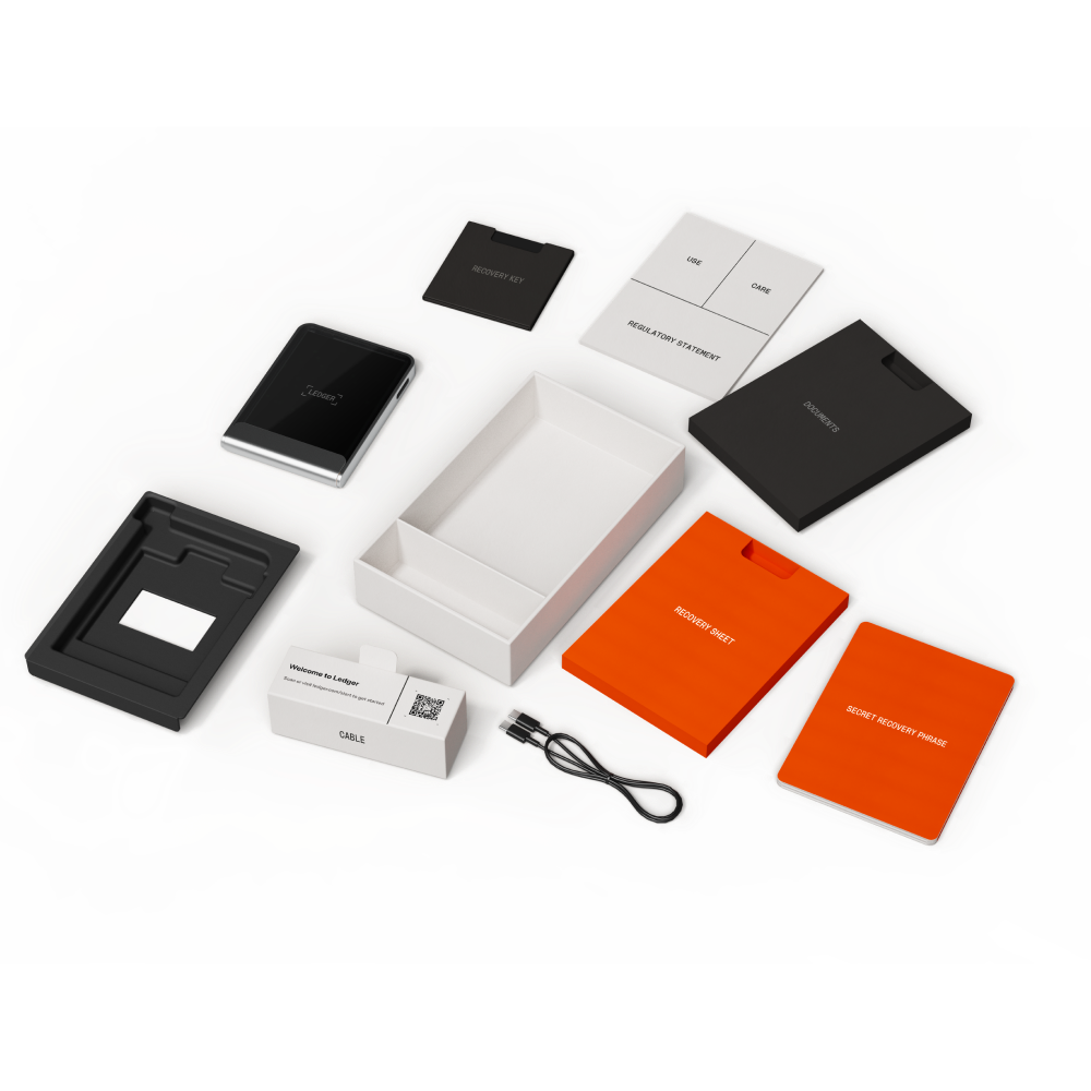 Paquete de billetera de hardware Ledger con dispositivo, hoja de recuperación, documentos, cable y caja. Los elementos están sobre una superficie colorida.