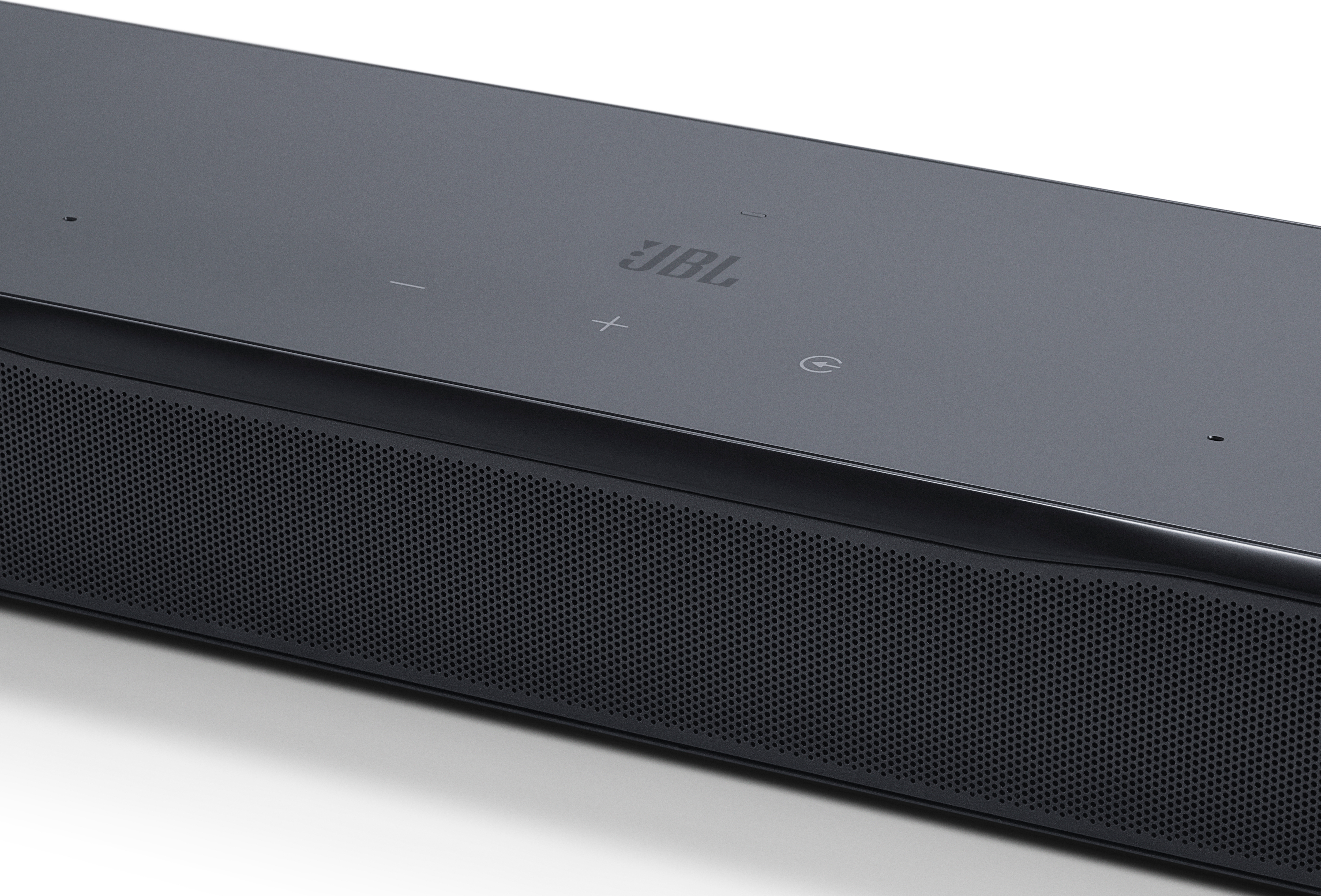 Schwarze JBL-Soundbar auf weißem Hintergrund. Die Oberseite hat Steuertasten und das JBL-Logo. Die Vorderseite hat einen Mesh-Lautsprecher.