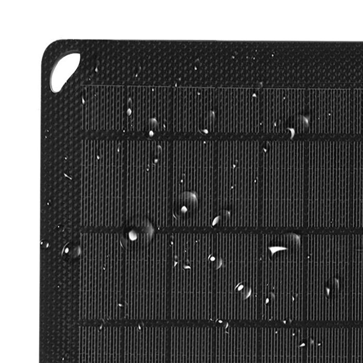 Nahaufnahme eines schwarzen rechteckigen Panels mit vertikalen Linien und Wassertropfen. Ein weißes Loch befindet sich oben links.