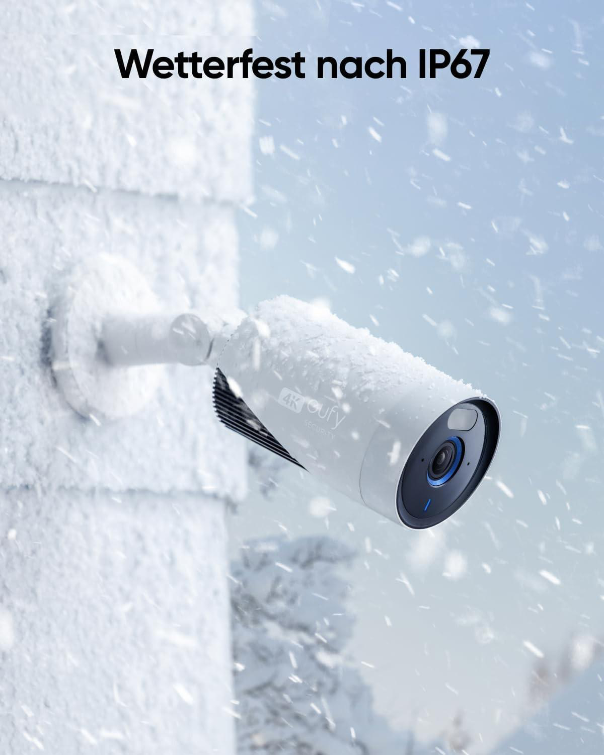 Weiße Überwachungskamera mit Schnee bedeckt, an einer verschneiten Wand montiert, Text 'Wetterfest nach IP67' darüber, in verschneiter Szene.