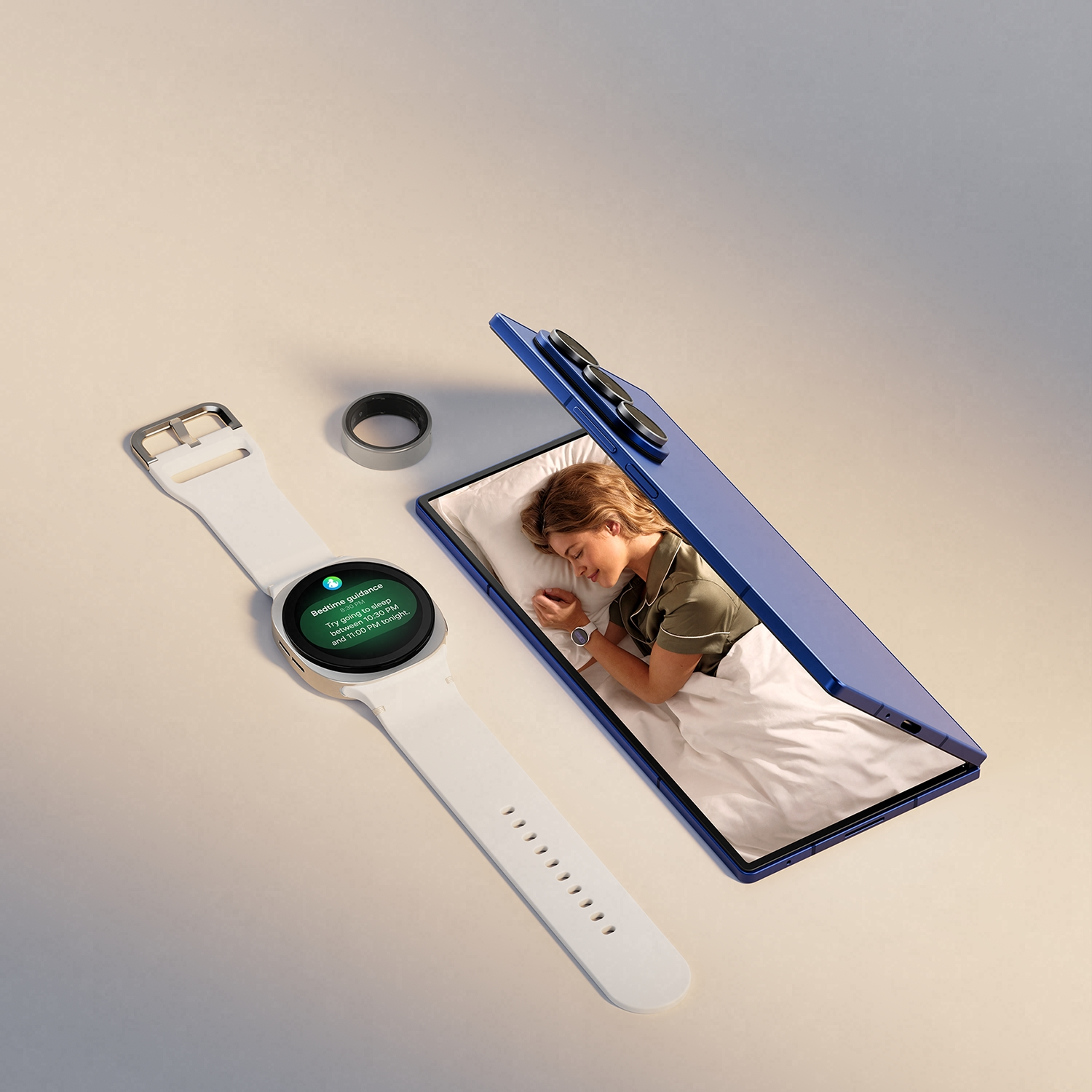 Un reloj inteligente, un anillo y un teléfono abierto muestran a una mujer durmiendo. El reloj muestra orientación para dormir.