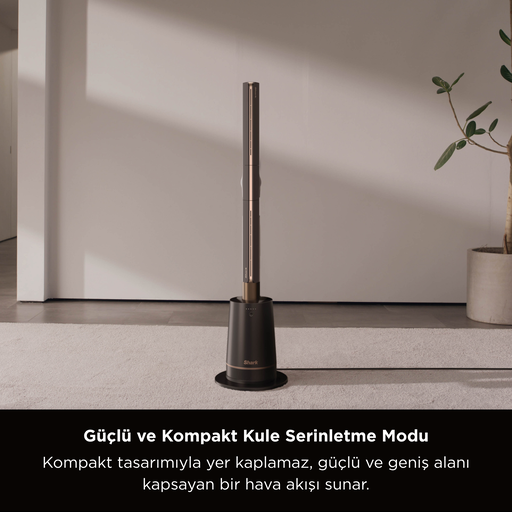 Siyah ve bronz bir kule fanı, beyaz bir halı üzerinde duruyor. Sağda bir bitki var. Arka plan beyaz bir duvar.