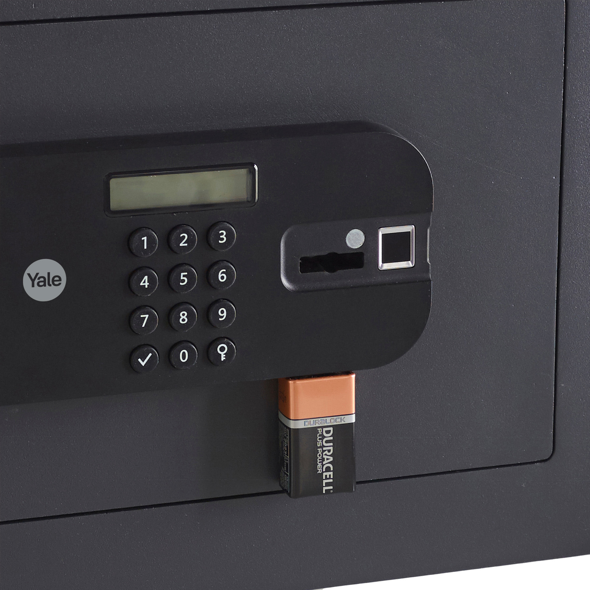 Eine schwarze Safetür mit Tastatur, Display und einer eingesetzten Duracell-Batterie. Das Yale-Logo ist sichtbar.