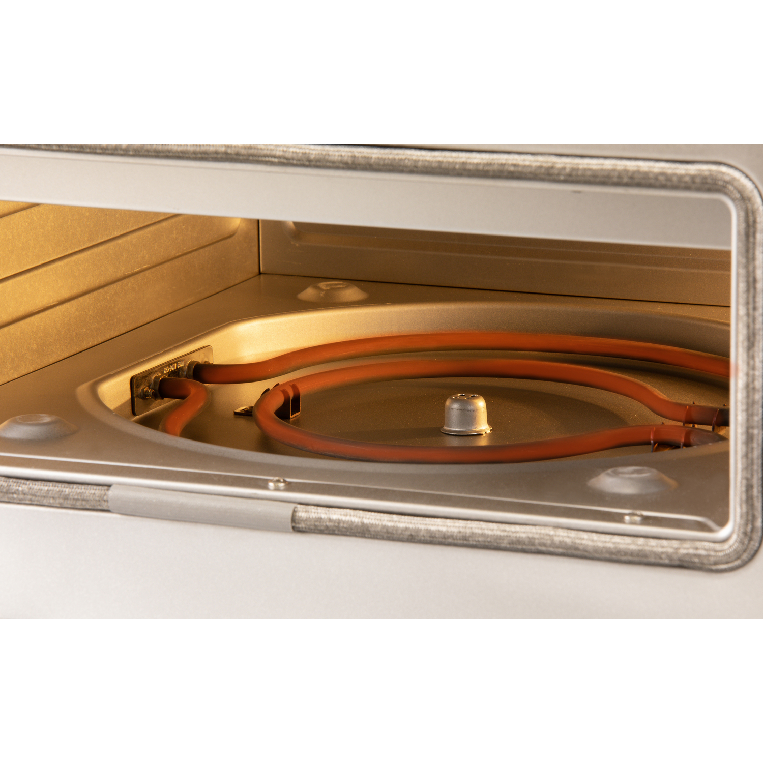 Inside a silver oven, a red heating element is visible. The interior is lit with a warm glow. The oven door is open.