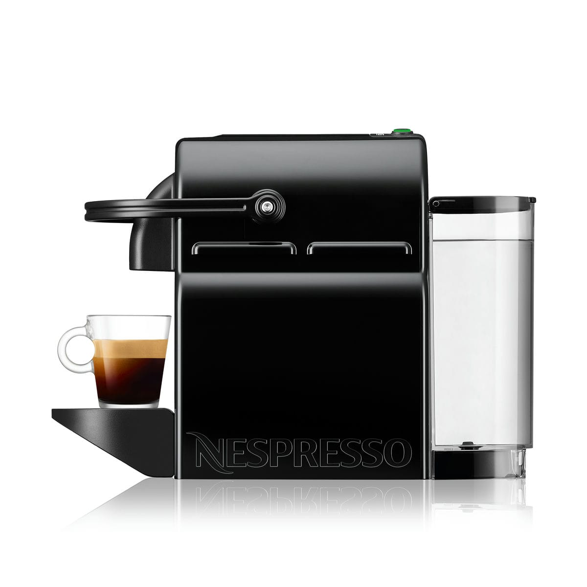Czarny ekspres Nespresso z filiżanką kawy po lewej. Zbiornik na wodę po prawej. Ekspres stoi na białej powierzchni.