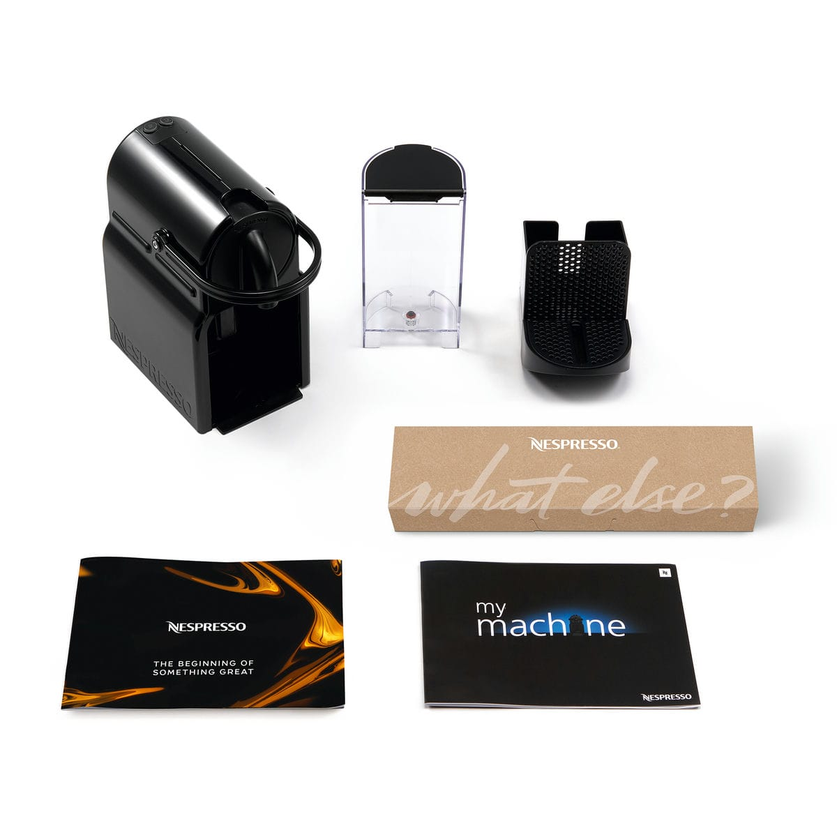 Elementy ekspresu Nespresso: czarny ekspres, zbiornik na wodę, uchwyt na filiżanki, pudełko i broszury na białej powierzchni.
