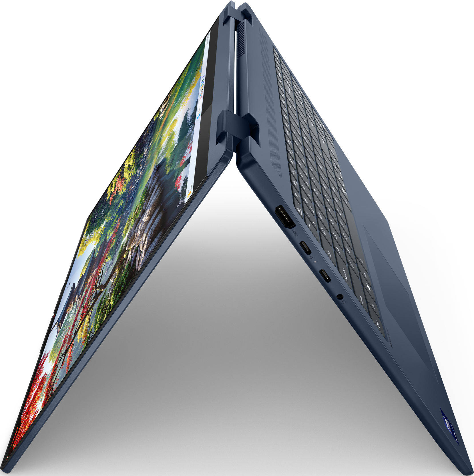 Blauer Laptop, geöffnet, angewinkelt. Der Bildschirm zeigt eine Landschaft. Tastatur sichtbar. Schwarzer Hintergrund.