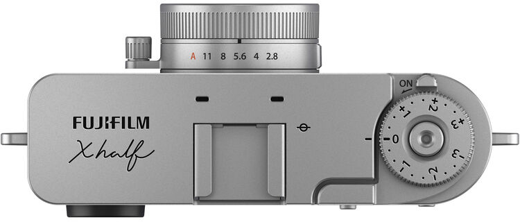 Ezüst Fujifilm Xhalf kamera felülnézete. Jellemzői: tárcsák, objektív beállítások és a 'FUJIFILM Xhalf' márkanév.